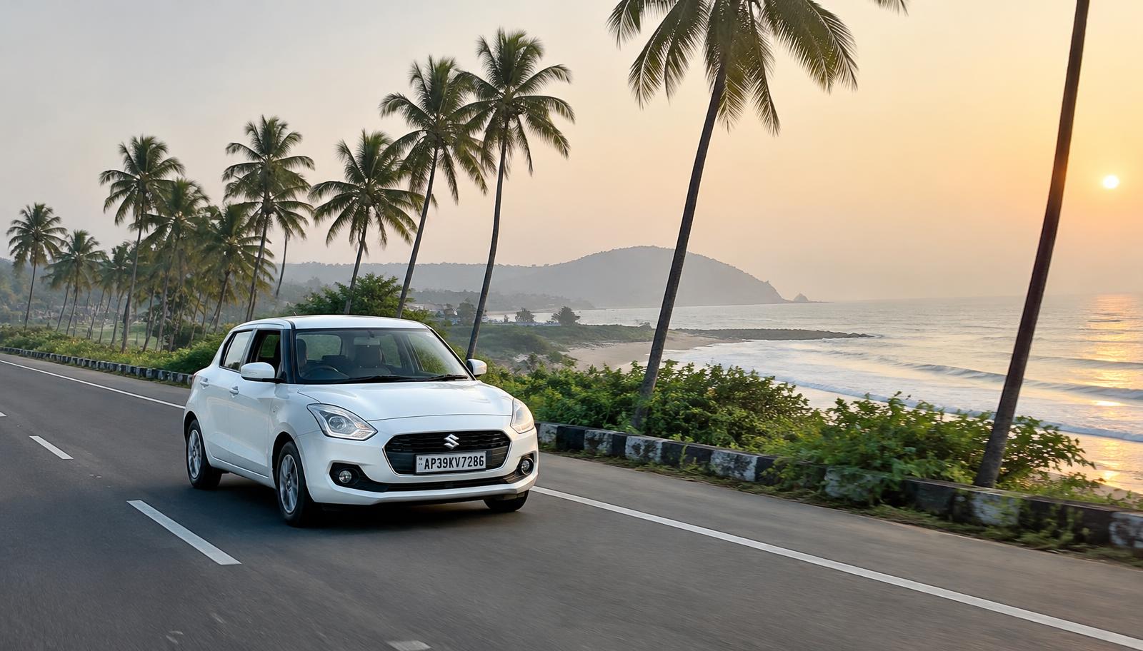 White Maruti Suzuki Swift on a coastal road with palm trees